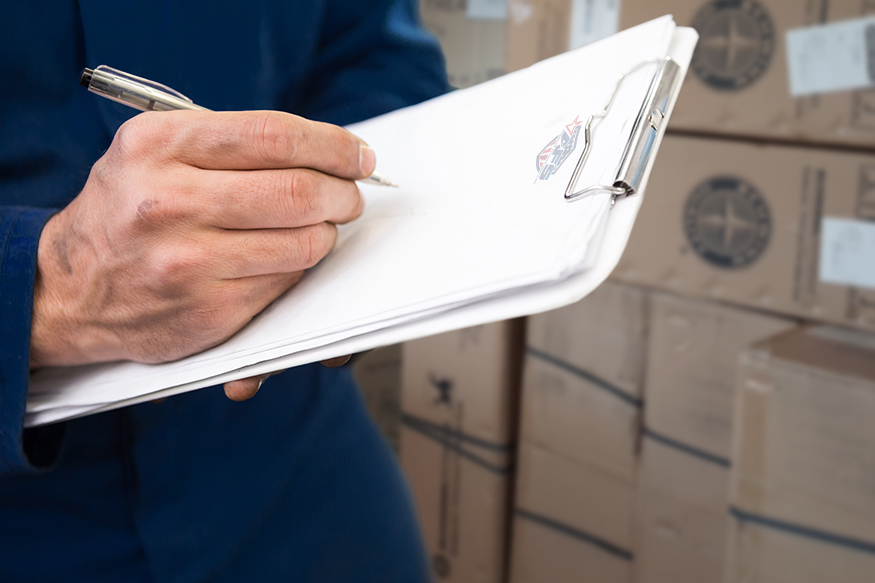 Close up of mechanic writing on clipboard